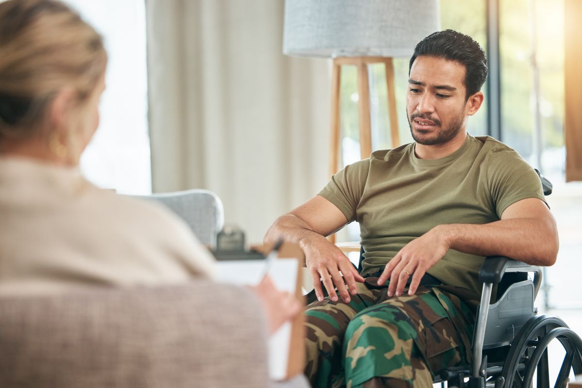 A veteran in a wheelchair receiving counselling.