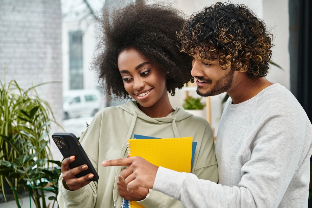A man and woman looking at a cell phone.